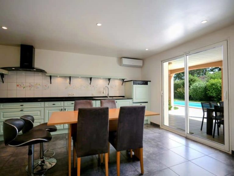 Cuisine équipée haut de gamme donnant sur une terrasse et vue sur la piscine