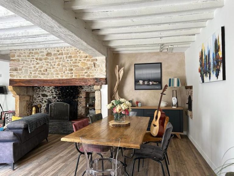 Vaste séjour avec cheminée en pierre, poutres et parquet dans une maison de charme près de Lescar